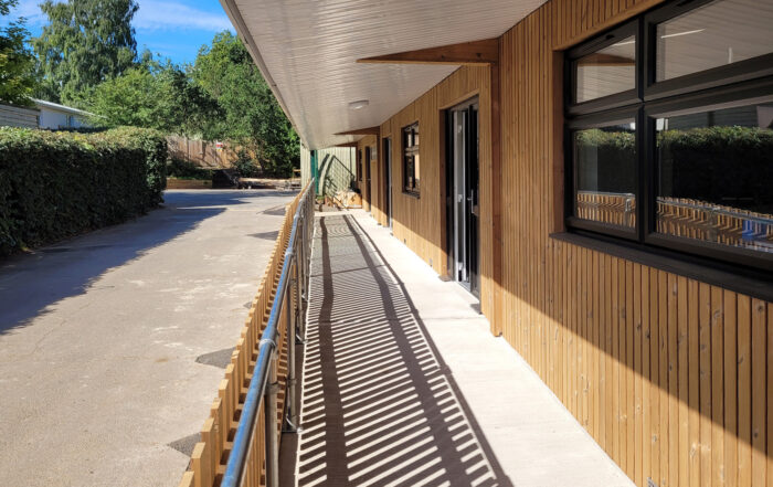 Timber-clad exterior of the Eccles Aurora School classroom block, designed by Norfolk architects Paul Robinson Partnership. Features include a covered walkway and contemporary design tailored to the needs of a non-mainstream educational environment.