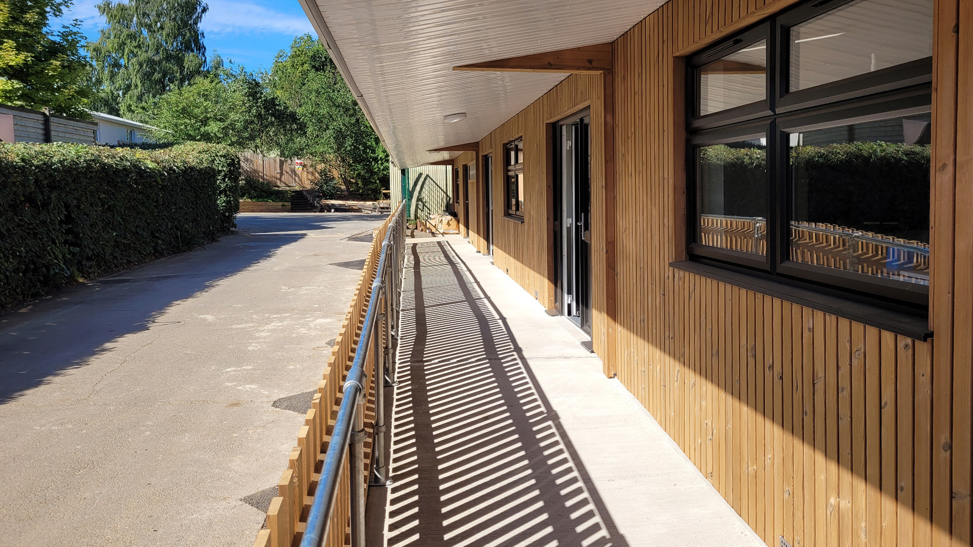 Timber-clad exterior of the Eccles Aurora School classroom block, designed by Norfolk architects Paul Robinson Partnership. Features include a covered walkway and contemporary design tailored to the needs of a non-mainstream educational environment.