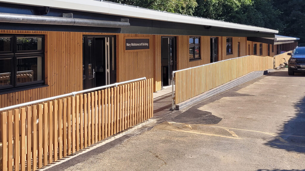 Contemporary timber-clad classroom block at Eccles Aurora School, designed by Norfolk architects Paul Robinson Partnership, featuring a covered walkway and purpose-built facilities tailored for non-mainstream education