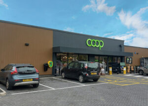 Modern Co-op store with parking area, designed by Norfolk architects Paul Robinson Partnership, showcasing contemporary retail architecture in a functional and accessible layout